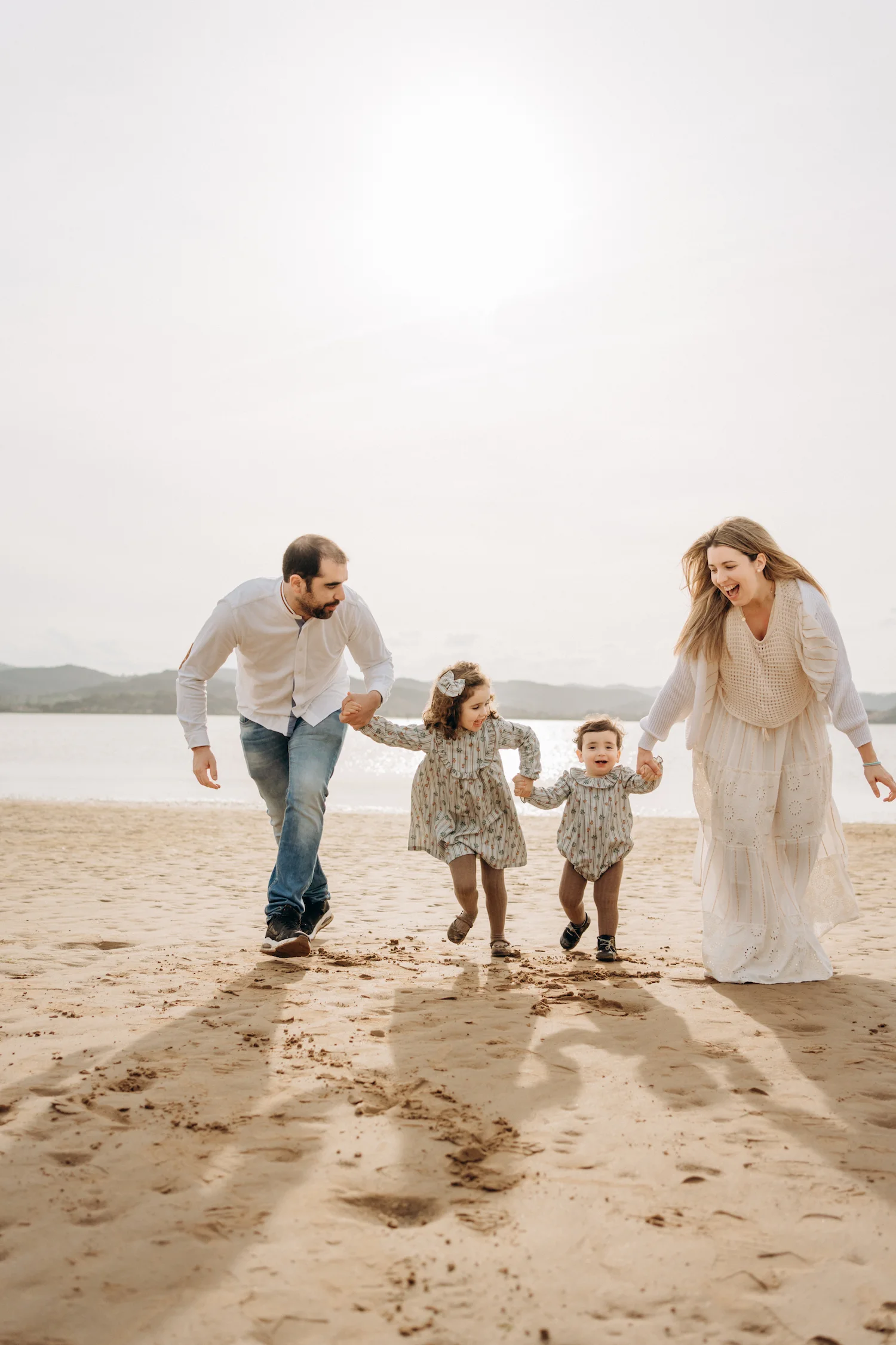 Familia paseando de la mano por la playa