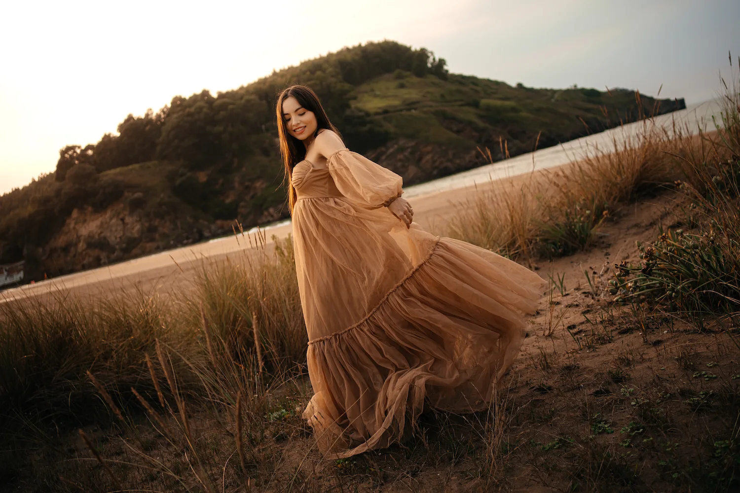 Mujer embarazada con un vestido ligero en un paisaje natural