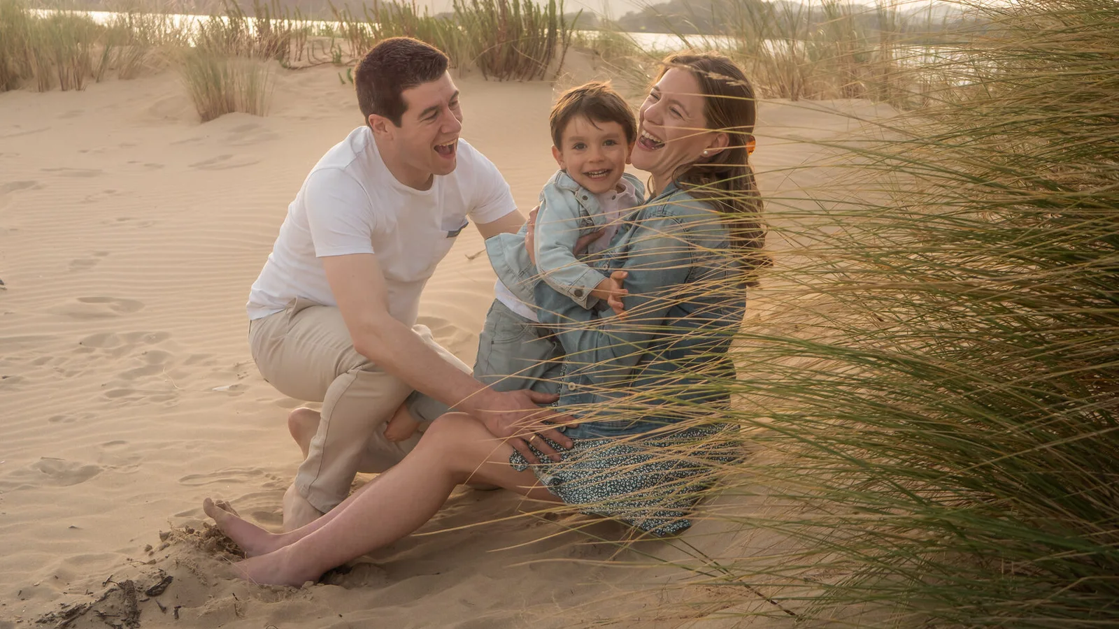 Padres jugando con su hijo en la playa